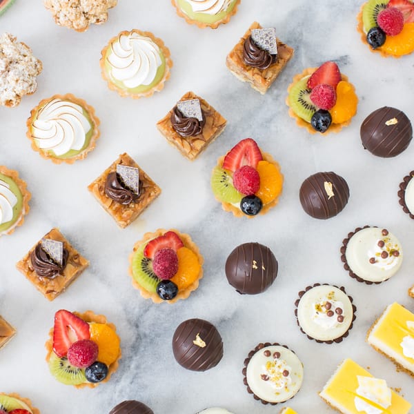 Assortment of Honeymoon Sweets European Bakery pastries, including fruit tarts, meringue tarts, and chocolate truffles.